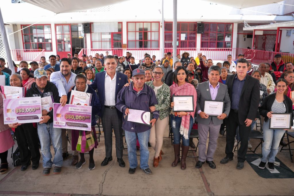 Grupo de personas en un evento de entrega de reconocimientos y premios en un espacio cubierto en Tlaxcala, México.