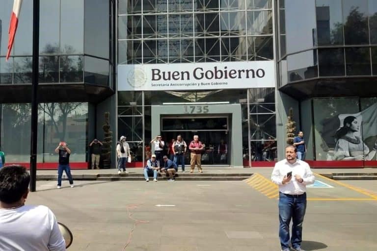 Edificio con cartel que dice "Buen Gobierno" en la entrada, con varias personas afuera, en un día soleado, en Tlaxcala, México, mostrando actividad cívica y participación ciudadana.