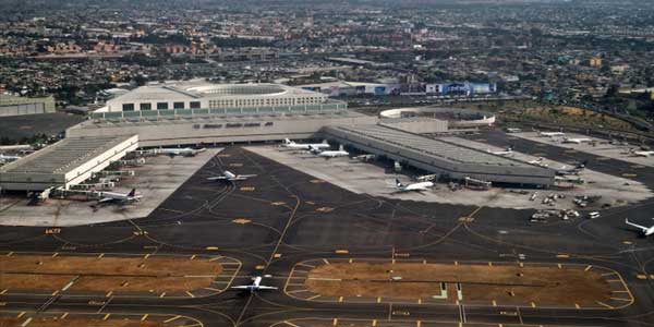 Aviónes en la pista del aeropuerto de Tlaxcala durante el día, con varias aeronaves estacionadas y en movimiento en una vista panorámica del aeropuerto.