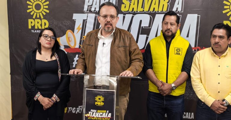 La imagen muestra a cuatro personas en un evento político, con un fondo que incluye logotipos del PRD y mensajes relacionados con la lucha social en Tlaxcala.