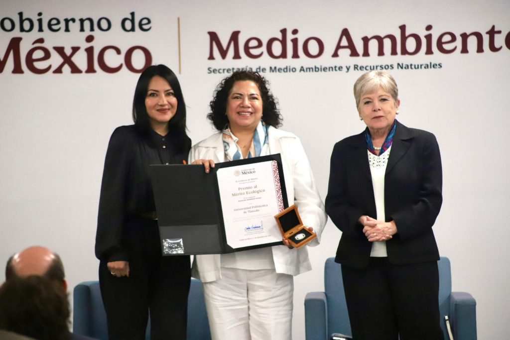 Reconocimiento de premiación en medio ambiente con tres mujeres en un evento oficial en Tlaxcala, México.