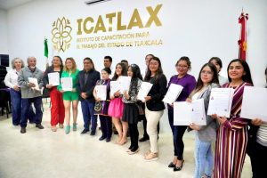 Capacitación para el trabajo en Tlaxcala, con participantes que reciben certificados en un evento formal en un salón del Instituto de Capacitación para el Trabajo del Estado de Tlaxcala (ICATLAX).