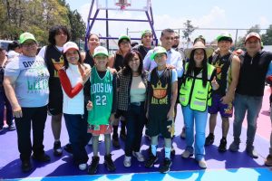 Grupo de niños y adolescentes en una cancha de baloncesto al aire libre, participando en una actividad deportiva en Tlaxcala, México.