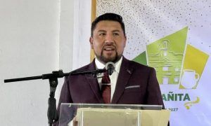 Hombre en traje oscuro hablando en un podio durante un evento oficial en Tlaxcala, México.
