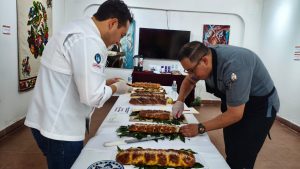Cocineros inspeccionando y preparando diferentes tipos de tamales en una mesa de exhibición en un evento culinario.