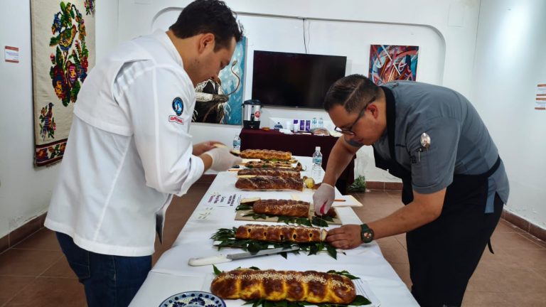 Cocineros inspeccionando y preparando diferentes tipos de tamales en una mesa de exhibición en un evento culinario.