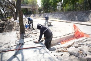 Cortador de pavimento y trabajadores en obra de reparación de calle en Tlaxcala, México.