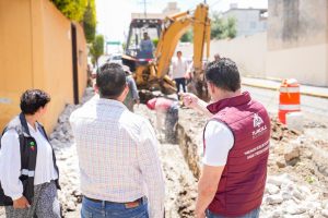Construcción de infraestructura en Tlaxcala, con maquinaria y personal trabajando en una obra en la calle.