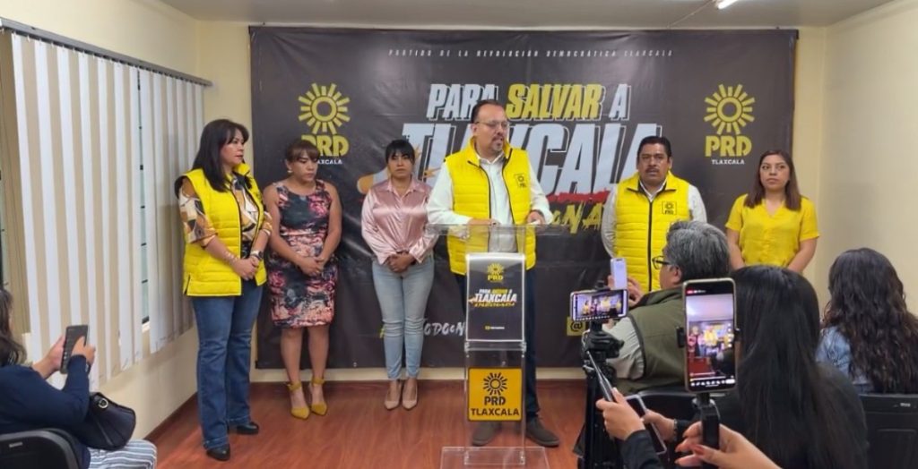 Grupo de personas en una conferencia de prensa con logotipos del PRD y un cartel que dice "Salvar a Tlaxcala".