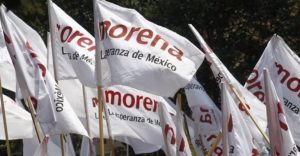 Banderas de Morena con el logo y lema "La esperanza de México" en un evento político en Tlaxcala.