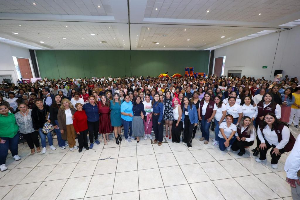 Personas reunidas en un evento masivo en un salón amplio, con muchas mujeres y algunos hombres, en un ambiente de convivencia y celebración.