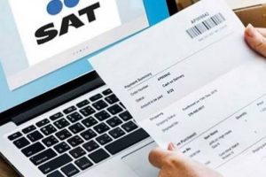 Comprobante de pago del SAT sobre una laptop, con código de barras y detalles visibles, en un entorno de oficina.