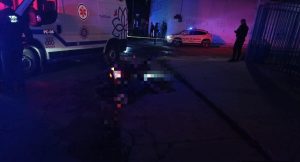 Escena de un accidente nocturno con una ambulancia y una patrulla en Tlaxcala, México, con presencia policial y un vehículo accidentado en la calle.