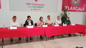 Panel de seis personas en una mesa con fondo de cartel que dice "Red Ciudadana para Defender a México" y bandera de Tlaxcala, participando en un evento político.