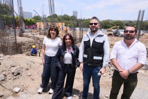 Construcción en progreso con cuatro personas en primer plano, supervisando el avance de la obra en un sitio de construcción en Tlaxcala, México.