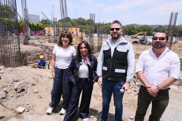 Construcción en progreso con cuatro personas en primer plano, supervisando el avance de la obra en un sitio de construcción en Tlaxcala, México.