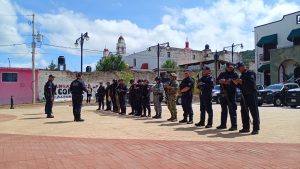 Policías en formación en una plaza pública de Tlaxcala, México, durante un ejercicio de entrenamiento o simulacro, con edificios y cielo nublado de fondo.
