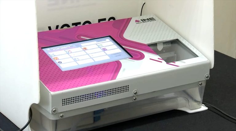 Voto electrónico en una casilla electoral, con una pantalla táctil y equipo de votación digital, utilizado para facilitar el proceso electoral en México.