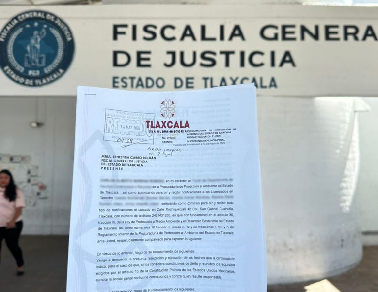 El documento oficial de la Fiscalía General de Justicia del Estado de Tlaxcala en primer plano, con un fondo que muestra el logotipo y el nombre de la institución en un edificio público.