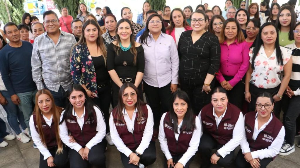 Estudiantes y docentes en una ceremonia escolar al aire libre, con muchas personas sonriendo y posando para la foto, en un ambiente de celebración y logro académico.