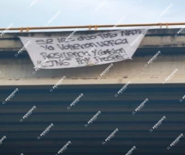 Señalización en una estructura de construcción con un cartel que contiene un mensaje escrito a mano en español.