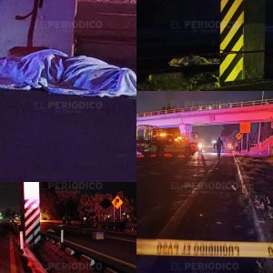 Muerto cubierto con sábana en la calle durante la noche, escena de un incidente vial con presencia policial y vehículos detenidos, señalización de precaución y cinta de seguridad en la escena del crim.