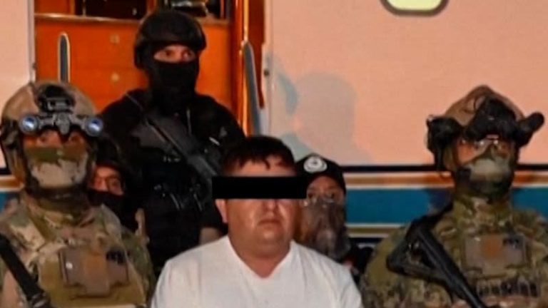 Hombre detenido rodeado de agentes militares y policiales en un operativo de seguridad.